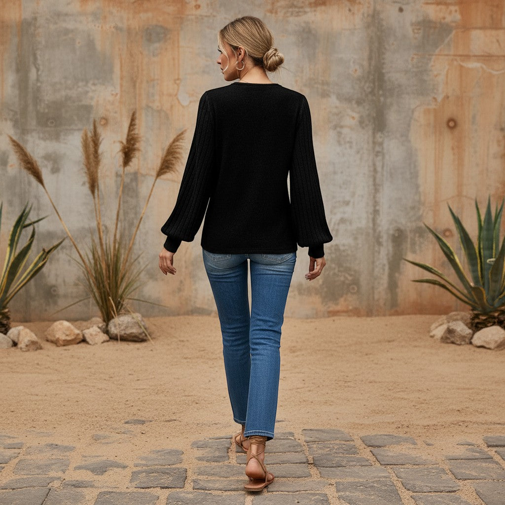 Bellem Trading black long-sleeve blouse with sculptural sleeves and V-neckline, made from a soft knit material.